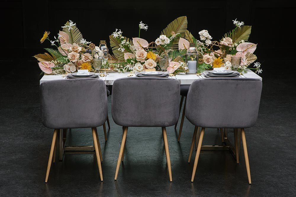 mid-century modern wedding table with velvet chairs, anthuriums and palm fronds