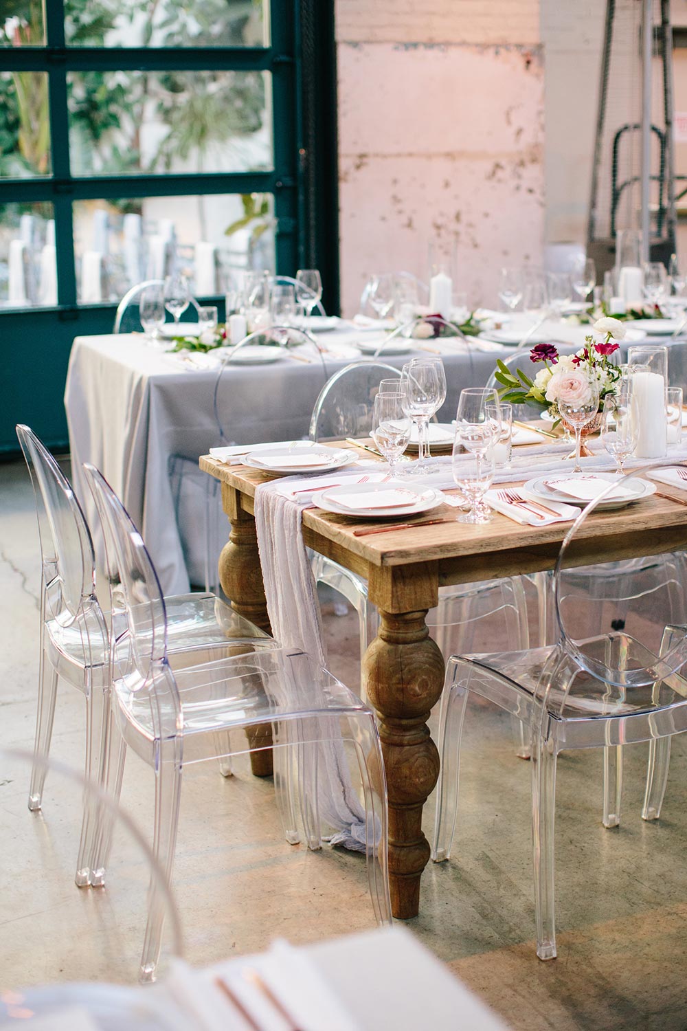 urban wedding reception with family style tables and ghost chairs